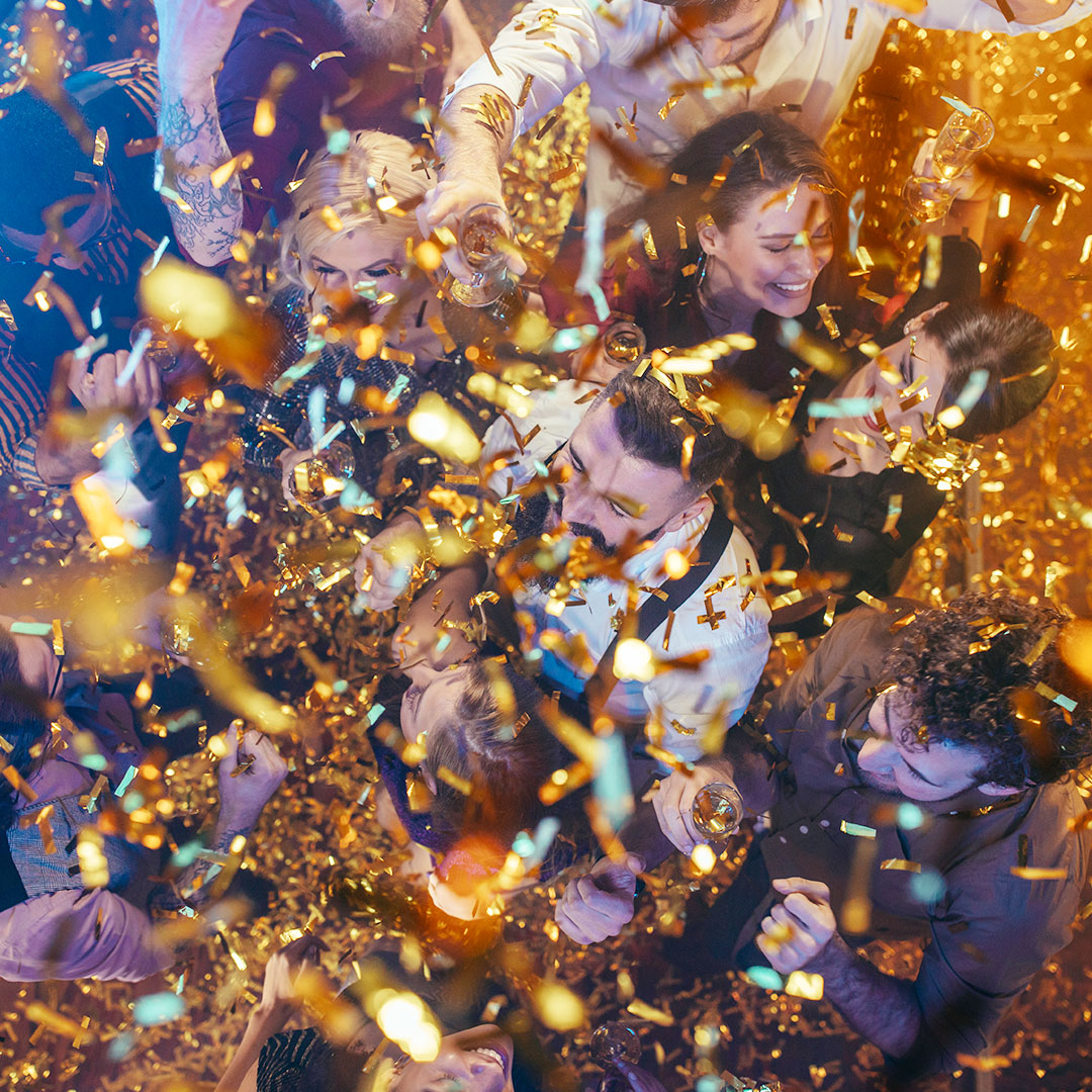 Group of People Partying on Dance Floor with Confetti Overhead