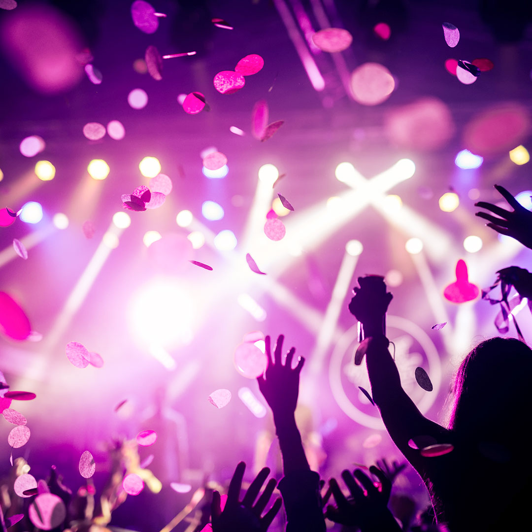 People Partying at Rave Festival Party Event with Confetti and Purple Lights